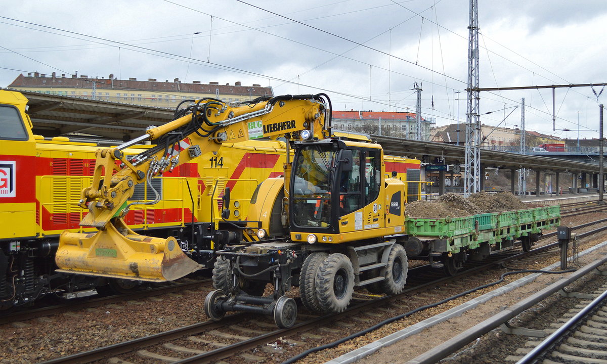 Ein LIEBHERR 922 rail Zweiqwegebagger mit Flachwagen (47 80 3360 041-7 D-BUG) der Fa.BUG Verkehrsbau AG mit Altschotter beladen am 15.03.19 Durchfahrt Bf. Berlin-Lichtenberg.