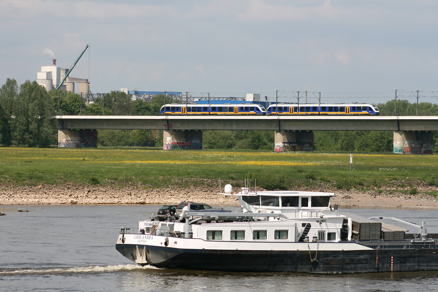 Ein LINT-Doppel der NWB (unterwegs als RE 10) begegnet im Bereich der Hammer Eisenbahnbrücke in Düsseldorf einem Binnenschiff, welches den Rhein stromabwärts befährt.
Aufnahmedatum: 04. Mai 2011
