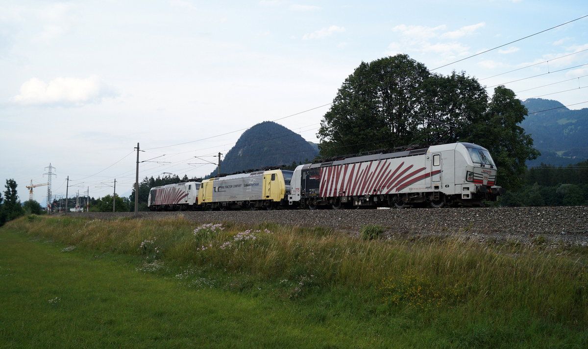 Ein Lomo-Lokzug fährt am 19.07.2019 bei Brixlegg im Abendlicht in Richtung Kufstein/Osten. Zwei  Teufelszebras , darunter die 193 775 am Zugschluss, schließen dabei eine im gelb/grauen Design gehaltene 189 ein.