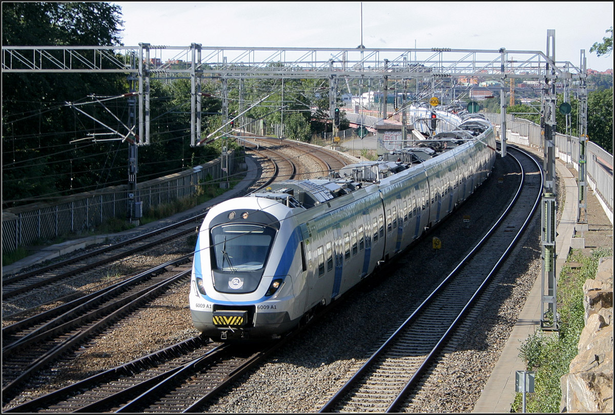 Ein moderner Zug für Stockholms Pendelzug -

Aus dem Konzept Coradia Lirex von Alstom wurde für den Stockholmer Pendelågverkehr (vergleichbar unserer S-Bahnen) der X 60-Triebzug (Coradia Nordic) weiterentwickelt. Die sechteiligen Züge sind etwa 107 Meter lang. Durch die größere Breite befinden sich auf einer Seite drei Sitze, auf der anderen Seite des Ganges zwei. Die für Deutschland bestellten Coradia Lirex-Triebzüge (BR 440) für Regionalverkehr in den Bereichen Augsburg und Würzburg werden nicht dieses elegante Design besitzen. Aufnahmestandpunkt südwestlich der Station Södra. 

29.8.2007 (M)