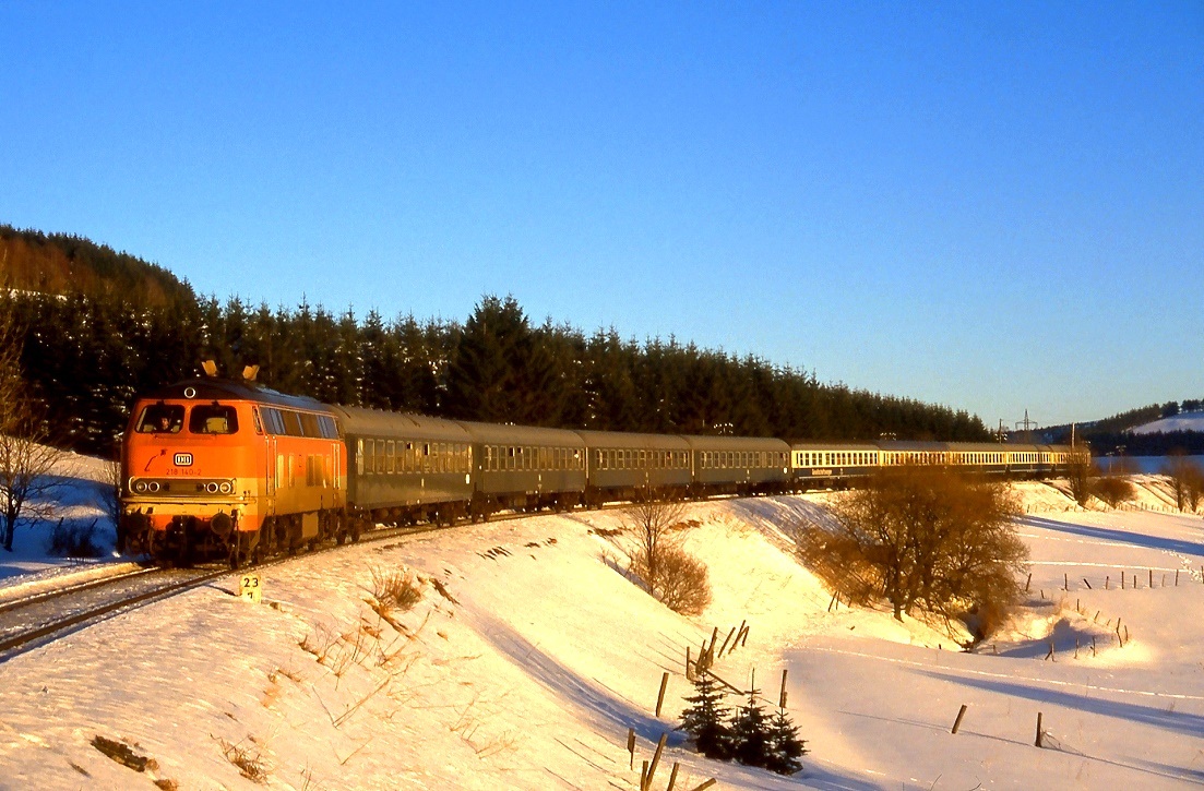 Ein Motiv aus der guten alten Zeit, als Wintersportler noch mit dem Zug ins Sauerland kamen. 218 140 bringt die Tagesausflügler zurück ins Ruhrgebiet, Aufnahme kurz nach der Ausfahrt aus Winterberg, 01.02.1987.