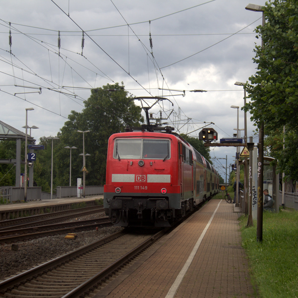 Ein Nachschuss von der 111 149 DB schiebt den RE4 aus Aachen-Hbf nach Dortmund-Hbf und kommt aus Richtung Aachen-West,Laurensberg,Richterich, und fährt durch Kohlscheid in Richtung Herzogenrath,Mönchengladbach,Neuss. Aufgenommen vom Bahnsteig 1 in Kohlscheid. 
Bei Sonne und Regenwolken am Nachmittag vom 18.6.2018.