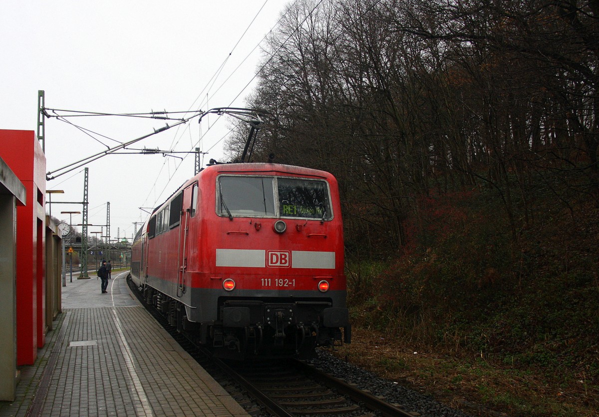 Ein Nachschuss von der 111 192-1 DB schiebt den RE1 aus Paderborn Hbf-Aachen-Hbf und hilt im Stolberger-Hbf bei Regenwetter am Kalten 13.12.2014.