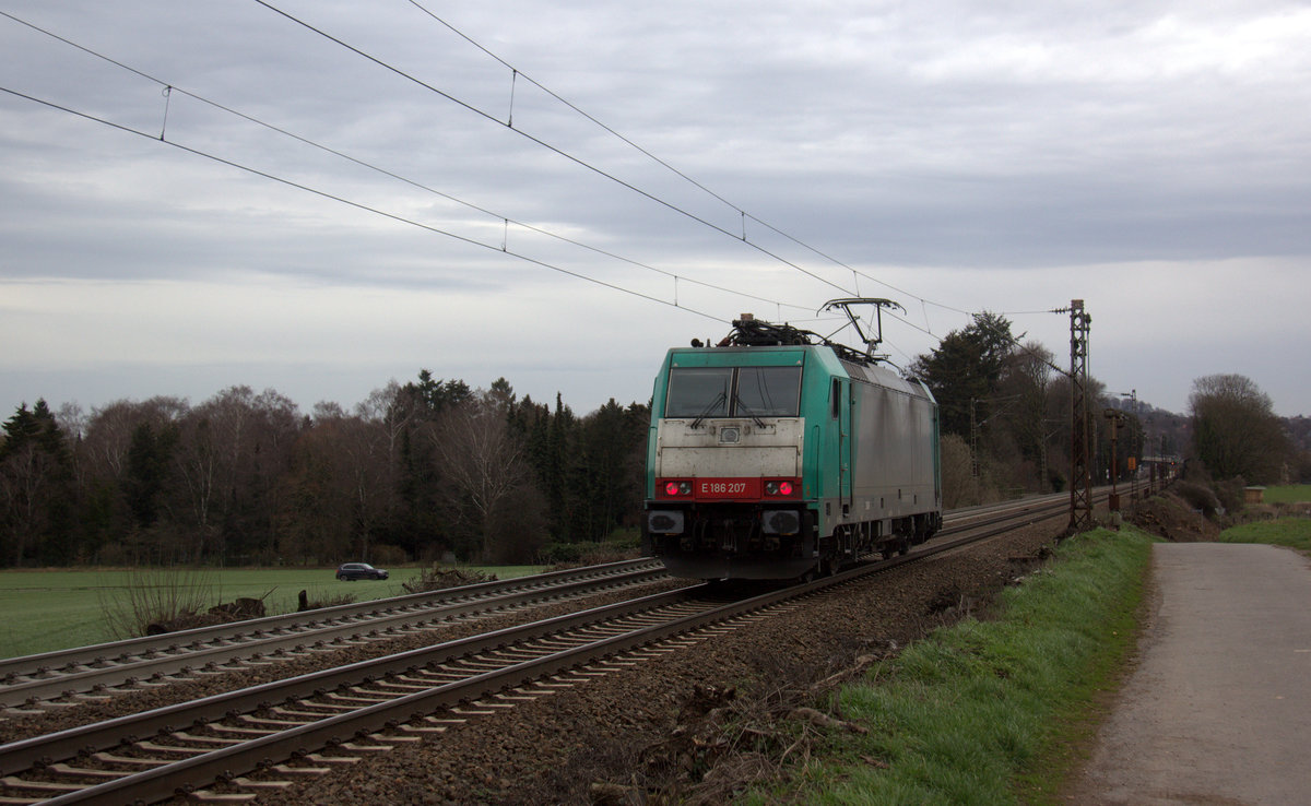 Ein Nachschuss von der 186 207 von der Rurtalbahn-Cargo und kamm als Lokzug aus Genk-Goederen(B) nach Aachen-West(D) die Gemmenicher-Rampe herunter nach Aachen-West. 
Aufgenommen an der Montzenroute am Gemmenicher-Weg. 
Bei Sonne und Regenwolken am Nachmittag vom 6.3.2019.