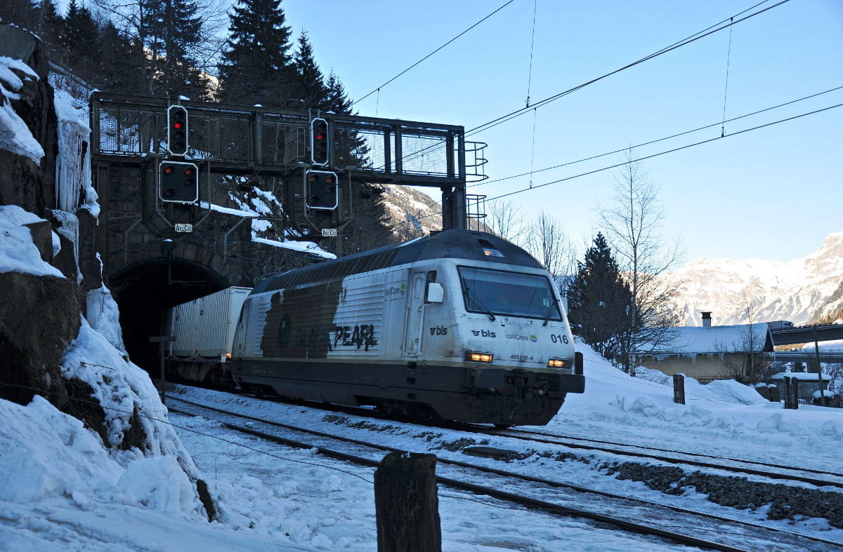 Ein nahezu perfekt getarnter Güterzug in der weissen Schnee- und Felsenlandschaft des Gotthards. Die BLS 465 016-4, welche für railCare unterwegs ist, verlässt mit ihrem Güterzug den Rohrbachtunnel bei Wassen und strebt weiter nordwärts. Aufgenommen am 10.02.2015.