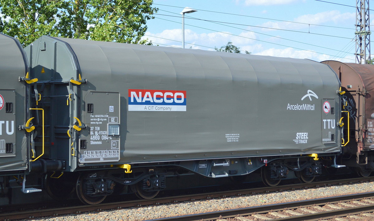 Ein neuer Drehgestell-Flachwagen für Coiltransporte mit Schiebeplane vom Einsteller VTG in der Schweiz mit niederländischer Registrierung mit der Nr. 37 TEN 84 NL-VTGCH 4669 084-4 Shimmns Firmenlogo:  NACCO  und  ArcelorMittal  am 01.07.19 Saarmund Bahnhof.