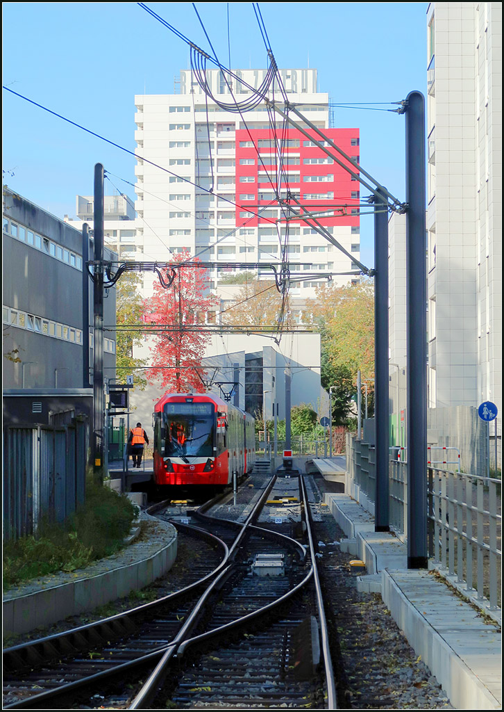 Ein neuer Endpunkt der Linie 3 -

Seit August erreicht die Kölner Stadtbahnlinie 3 das Görlinger Zentrum. Schon seit Juni 2002 ist das erste Teilstück dieser Neubaustrecke mit zwei Haltestellen in Betrieb. Mit dem Reststück dauerte dann ganze 16 Jahre. Ursprünglich war ein Tunnelhaltestelle sicher in günstigerer Lage geplant, aber darauf wurde letztlich verzichtet und eine kostengünstige oberirdische Lösung gefunden, eingezwängt zwischen einer Schulanlage und Wohnbauten. Die Lage ist dabei leider nicht mehr so zentral im Wohngebiet, wie es mit der zunächst geplanten Tunnelanlage gewesen wäre. 

Wie man an den in die anderen Bilder aus der Gegenrichtung sehen kann, macht die Trasse hier einen Gleisbogen. Ich stehe also nicht auf dem Gleis. Der Gleisbereich ist zudem eingezäunt.

16.10.2019 (M)