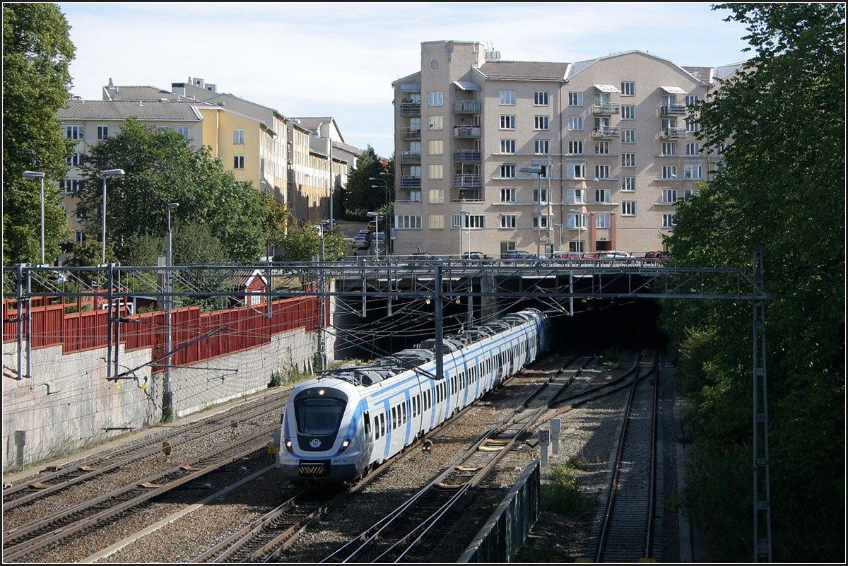 Ein neues Viertel über dem Bahnhof -

Ein X 60-Pendeltagzug kommt aus dem Tunnel im Bereich der Station Stockholm Södra auf der Fahrt in südwestlicher Richtung.
Der früher offene Bahnhof wurde in den achziger Jahren mit einem neuen Stadtviertel überbaut. 

29.08.2007 (M)