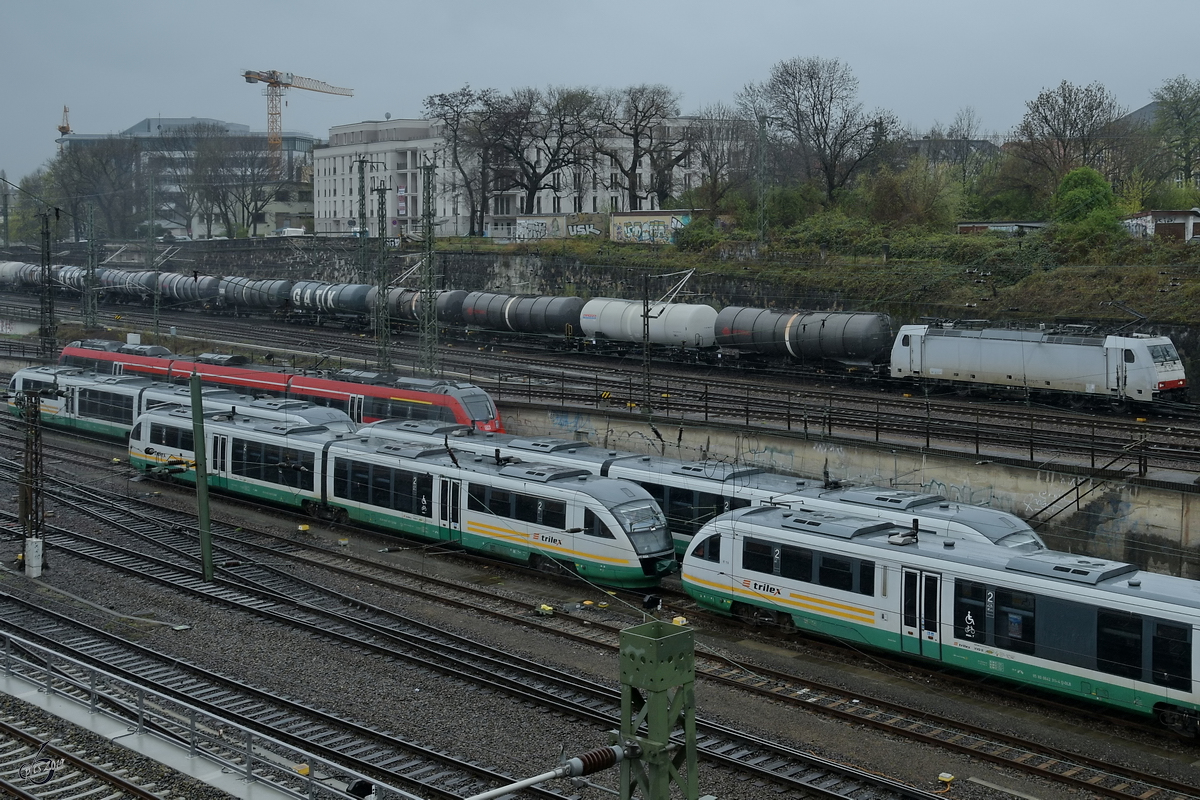 Ein paar geparkte Trilex 642-Triebzüge, im Hintergrund die vor einem Güterzug gespannte 186 137 bei der Durchfahrt. (Dresden Hauptbahnhof, April 2017)
