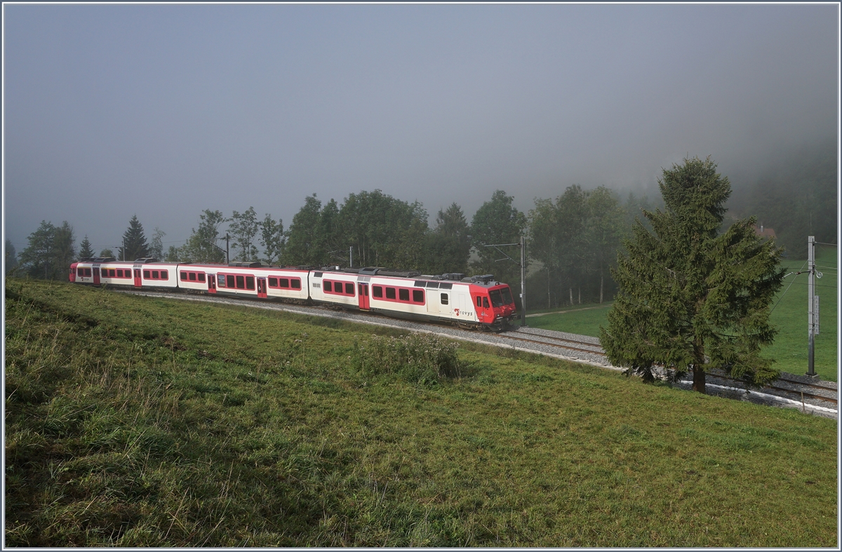 Ein paar Minuten später kommt bereits der Gegenzug 6014 Richtung Vallorbe mit dem RABDe 560 385-7 (UIC RABDe 560 DO TR 94 85 7 560 385-7 CH-TVYS) den Lac de Brennet entlang gefahren und der Nebel hat sich bereits sichtlich gelichtet.
Bei Le Pont, den 28. August 2018