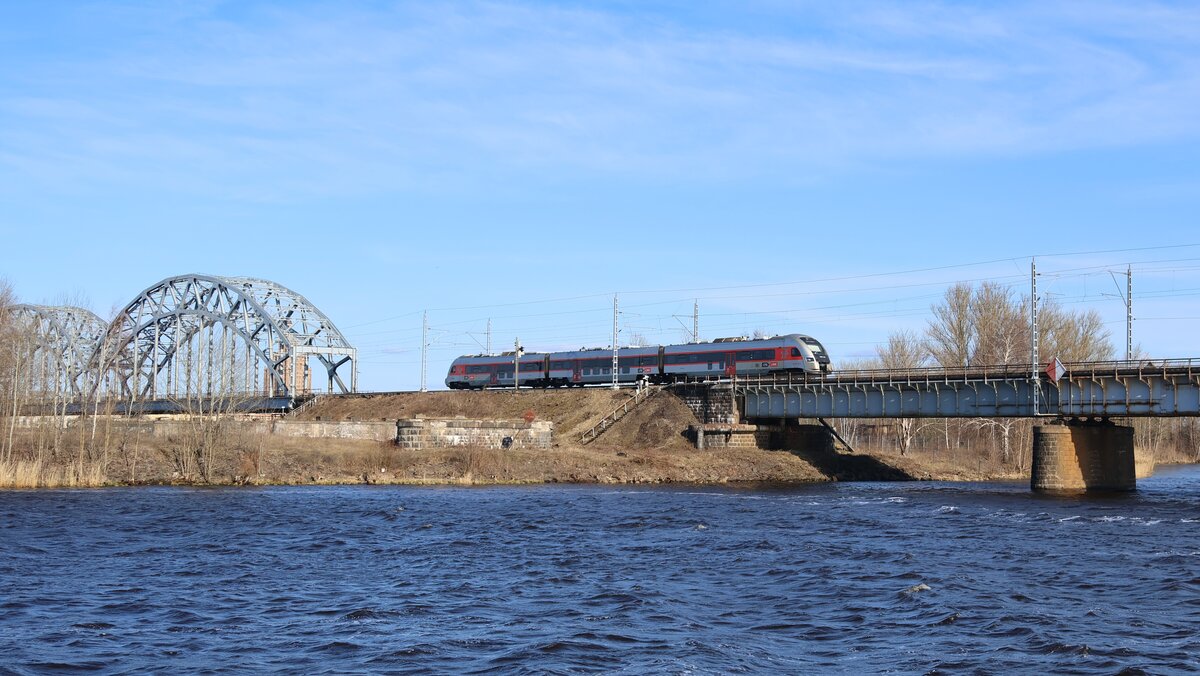 Ein Pesa 730ML der LTG Link als internationaler Zug 891 Valga - Vilnius bei der Überfahrt des Flusses Daugava kurz nach Verlassen des Rigaer Hauptbahnhofes.
Aufgenommen im April 2026.
