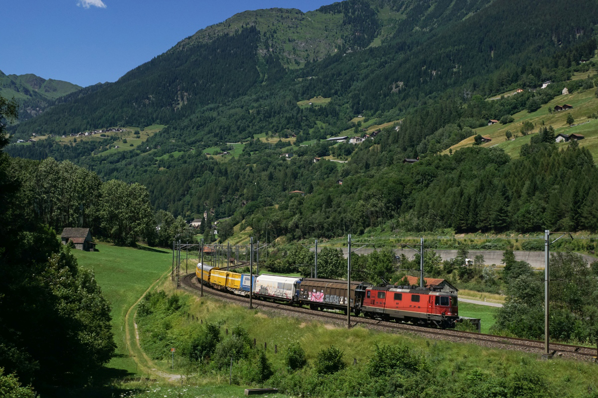 Ein Postzug mit der Re 4/4 II 11277 an der Spitze rollt am 19.07.2016 die Gotthard-Südrampe hinunter (Rodi-Fiesso, 19.07.2016).