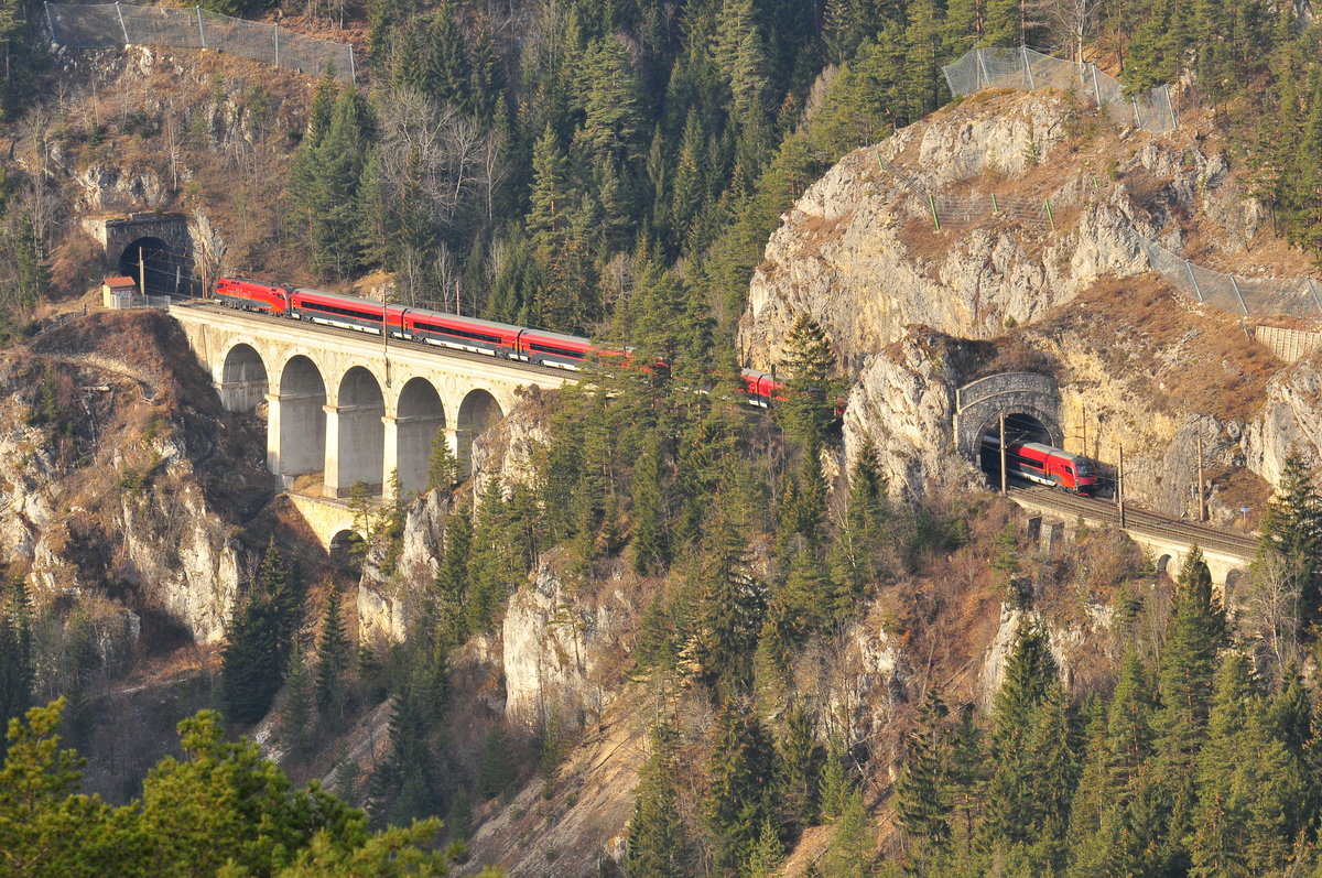 Ein Railjet der ÖBB befährt das Krausel-Klause-Viadukt und den gleichnamigen Tunnel der Semmering Bahn. Das Foto entstand am 02.01.2016 vom sog.20 Schilling Blick auf der gegenüberliegenden Bergseite.