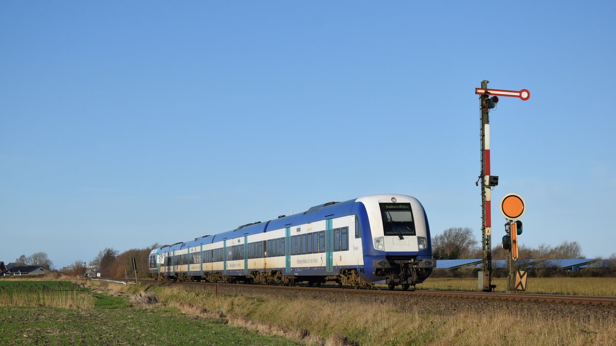 Ein RE6 nach Hamburg Altona hat soeben Klanxbüll verlassen und passiert hier gerade das Einfahrsignal der Gegenrichtung. Aufgenommen am 9.1.2019 12:49