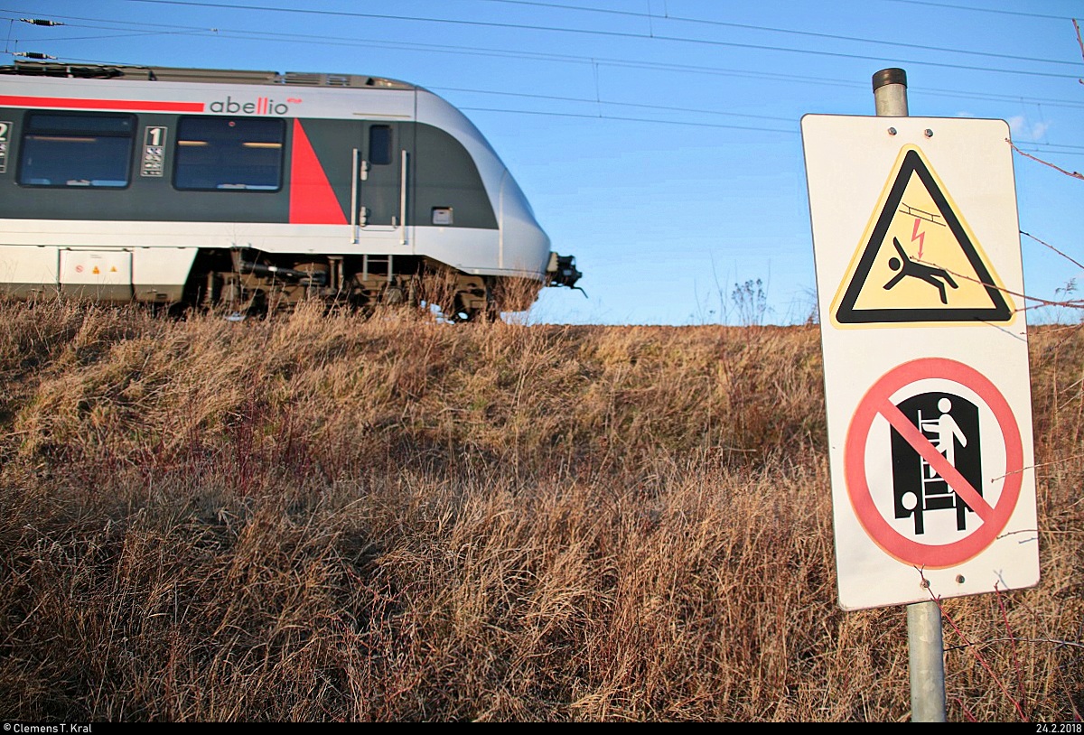 Ein Schild am Roßgraben in Angersdorf weist auf die Gefahr der Oberleitung auf dem stillgelegten Gleis hin, wenn man wohl auf einen abgestellten Güterwagen klettert (meine Interpretation).
Oberhalb fährt eine BR 9442 (Bombardier Talent 2) von Abellio Rail Mitteldeutschland als RE 74713 (RE9) von Kassel-Wilhelmshöhe nach Halle(Saale)Hbf Gl. 13a auf der Bahnstrecke Halle–Hann. Münden (KBS 590) [24.2.2018 | 16:47 Uhr]