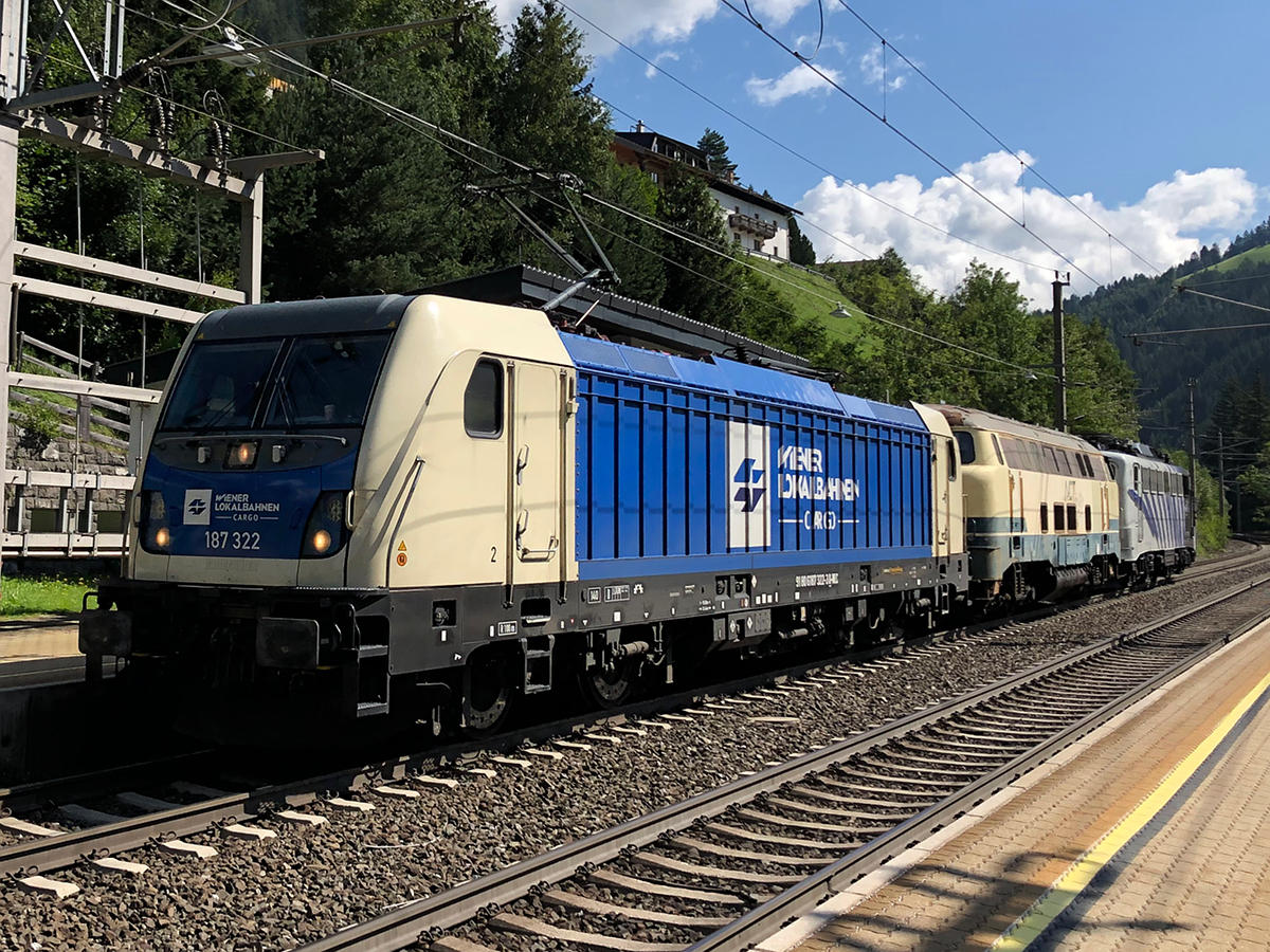 Ein sehr seltener Gast auf der Brennerbahn. 187 322-3 der Wiener Lokalbahnen bei einer Überstellungsfahrt einer Dieselok und einer Lokomotion 139 bei der Talfahrt Richtung Innsbruck. Aufgenommen am 20.08.2021 bei der Durchfahrt in St. Jodok am Brenner