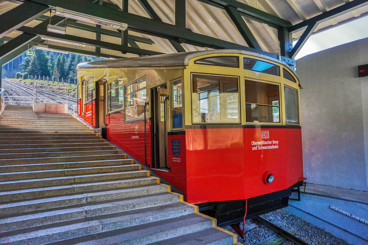 Ein Standseilbahnwagen der Oberweißbacher Bergbahn wartet im Bahnhof Obstfelderschmiede auf die Abfahrt nach Lichtenhain an der Bergbahn.
Unterwegs war der Wagen als RB 29840.
Aufgenommen am 9.4.2016.