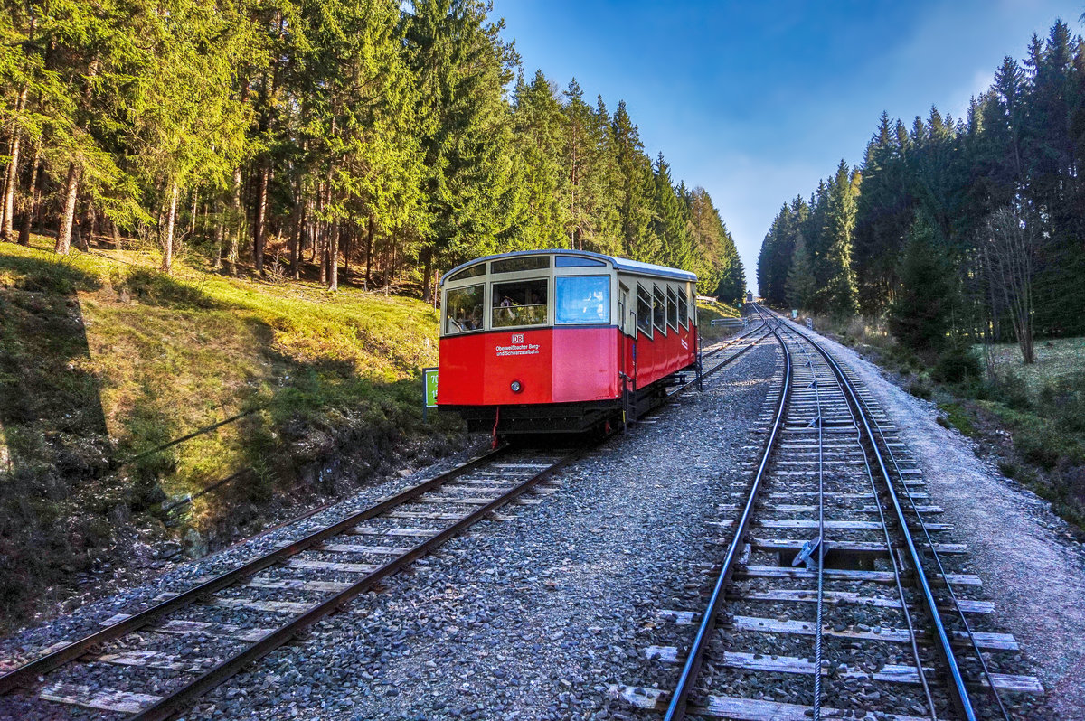 Ein Standseilbahnwagen der Oberweißbacher Bergbahn zwischen Obstfelderschmiede und Lichtenhain auf seiner Talfahrt.
Unterwegs war der Wagen als RB 29841.
Aufgenommen bei der Ausweichstelle, am 9.4.2016.