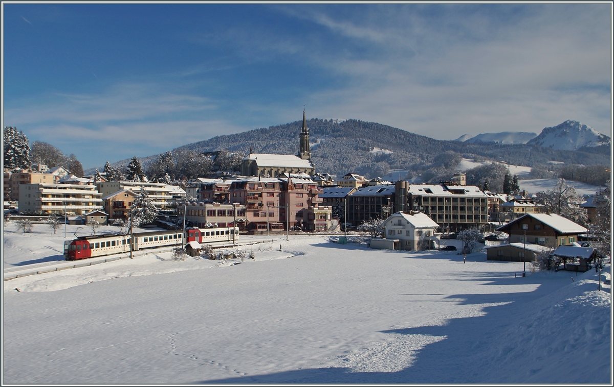 Ein TPF Regionalzug ist auf der  Palézieux -Linie bei Châtel St-Denis unterwegs. Heute befindet sich der neuen (Durchgangs)-Bahnhof beim linken Bildrand und der alte Bahnhof im Ort hat keinen Bahnanschluss mehr. 

21. Januar 2015