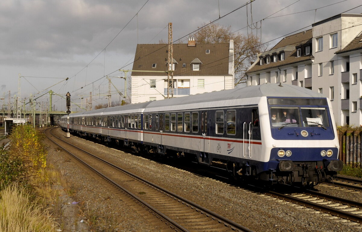 Ein von TRI gestellter 8-teiliger n-Wagen-Zug  fährt, geschoben von der GfE-111 200 als RE 1-Verstärker Dortmund - Köln durch Düsseldorf Derendorf. Aufnahme vom 27.11.21.