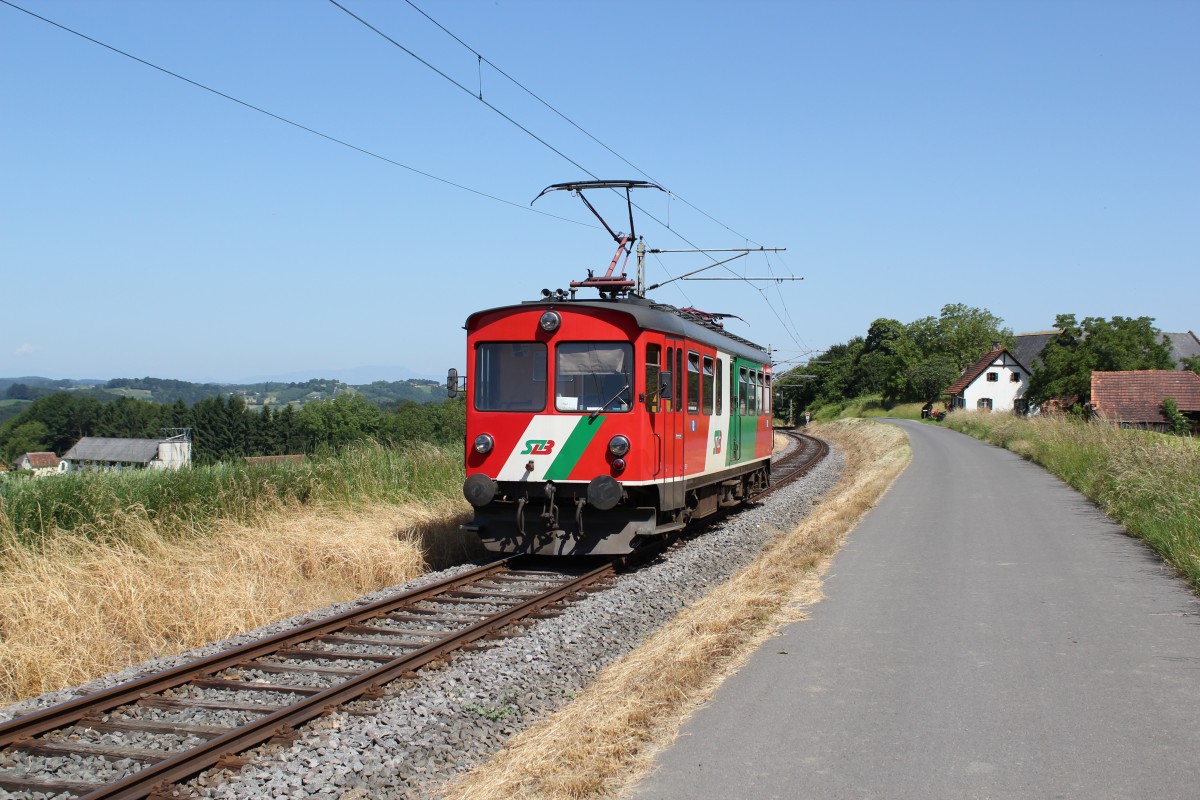 Ein Triebwagen der Gleichenberger Bahn hier bei Km 11,3 in der Nähe der Haltestelle Burgfried mit Blick über das oststeirische Hügelland auf der Fahrt nach Feldbach, Juni 2014
