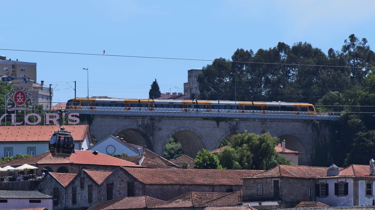 Ein Triebzug der Baureihe 3400 berquert die Mirador Gaia Brcke. Das Foto wurde mit Teleobjektiv aus etwa 1 Kilometer Entfernung vom anderen Ufer des Duoro am 09.06.2017 geschossen.