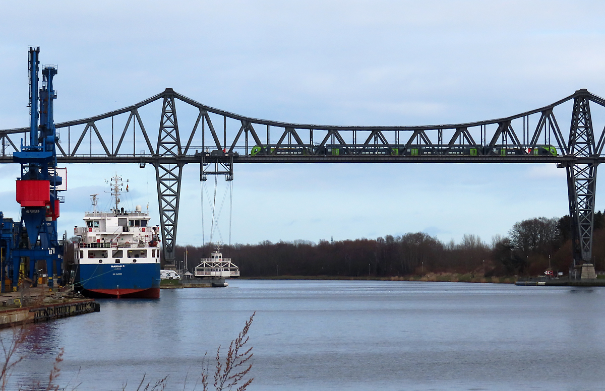 Ein Twindexx Vario überquert auf der Rendsburger Hochbrücke den Nord-Ostsee-Kanal, während sich die Schwebefähre am Nordufer befindet. Rendsbrug, 5.3.2023