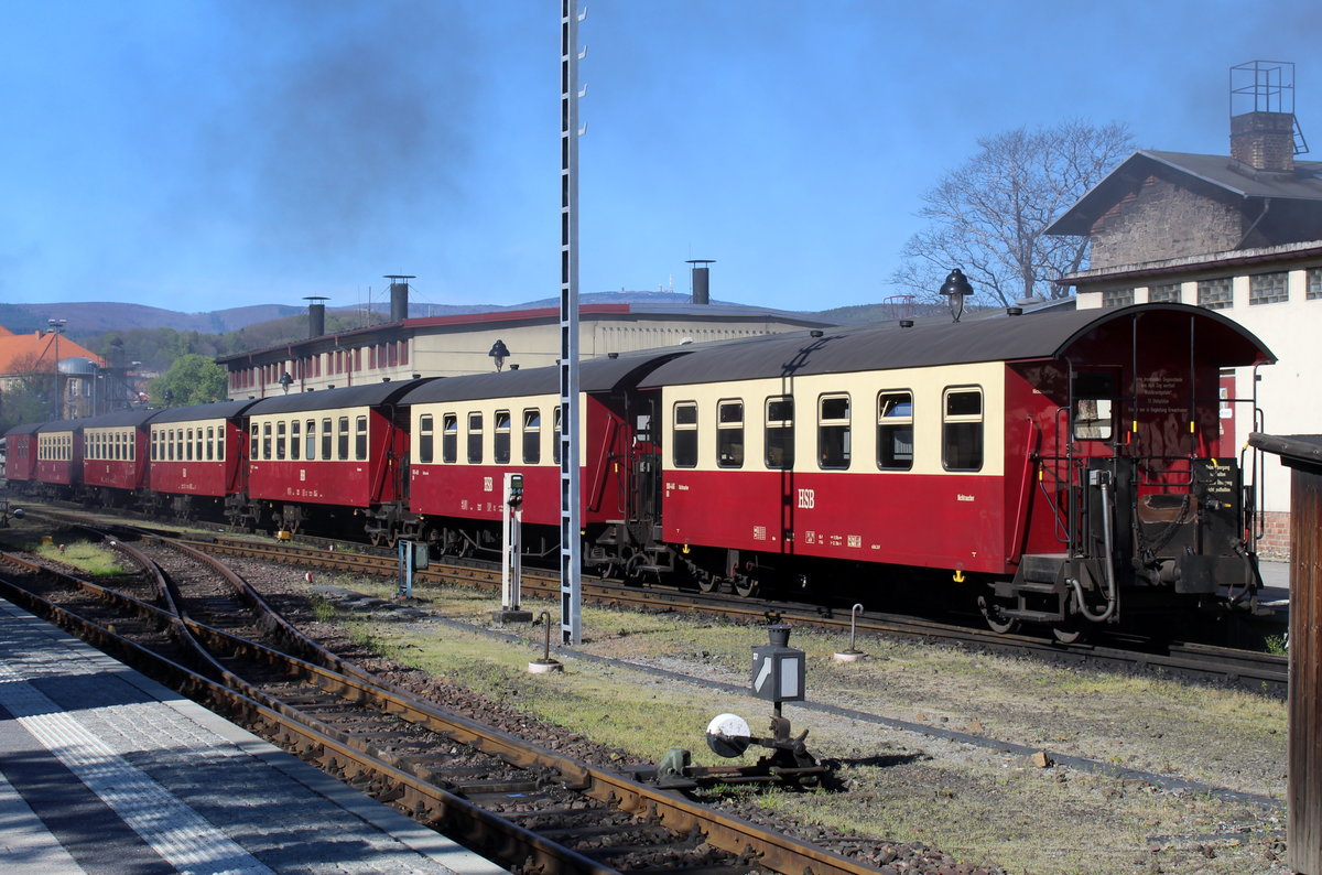 Ein typischer 7 Wagen-Brockenzug stand am 25.04.19 in Wernigerode abgestellt. Über dem Dach der Lokhalle, rechts vom Mast, erkennt man leicht den Brockengipfel.