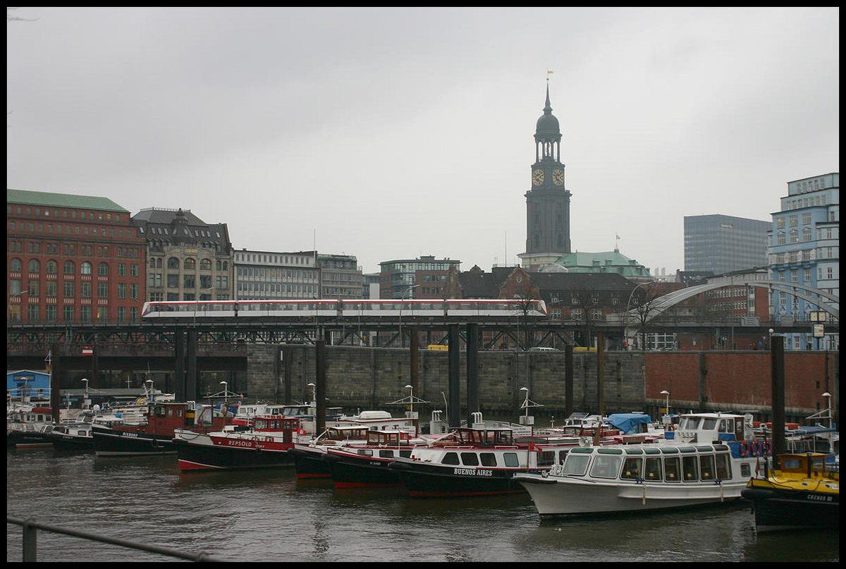Ein U-Bahn Zug ist hier am 9.3.2007 auf der Binnenhafen Brücke am 9.3.2007 vor dem im Hintergrund empor ragenden Michel Turm unterwegs.