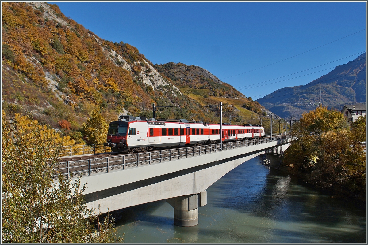 Ein Walliser (RegionAlps) Domino auf der Fahrt nach Brig überquert bei Leuk die Rhône und erreicht unmittelbar danach den Bahnhof von Leuk.

26. Okt. 2015