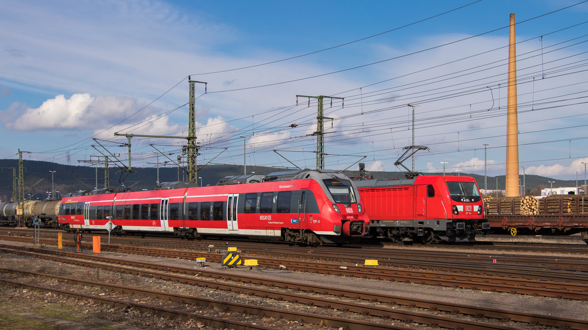 Ein Wettrennen, so könnte man meinen. 187 144-1 steht am 29. März 2018 im Hintergrund. 
442 108 ist vorne und überholt gerade den wartenden Güterzug im Bahnhof Saalfeld. 