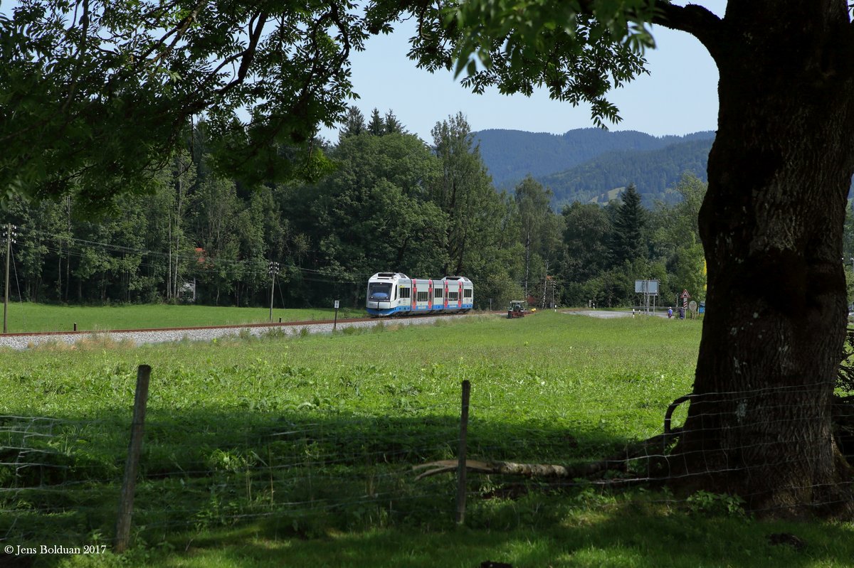 Ein Zug der BOB hat gerade eben den Haltepunkt Fischbachau in Richtung Schliersee verlassen