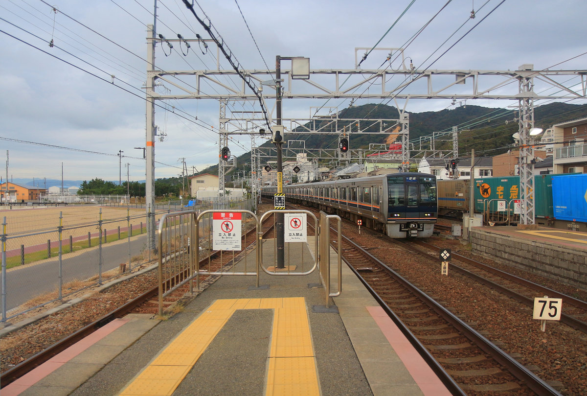 Ein Zug der Serie 207 (No. KUHA 207-12) bei der Einfahrt in Suma. Diese 4-türigen Gleichstromzüge für den Verkehr mit Halt an allen Stationen im S-Bahnverkehr um die grossen Städte Kyôto - Ôsaka - Kôbe haben im Inneren Längssitze, um möglichst viel Stehplatz zu schaffen. Die Züge verkehren auch über die JR-U-Bahnlinie (JR Tôzai Linie) durch Ôsaka hindurch. Es gibt heute 69 4-Wagenzüge, 67 3-Wagenzüge (einer stillgelegt) und einen 7-Wagenzug. Gebaut 1991-2003. 6.November 2018  SANYÔ HAUPTLINIE 