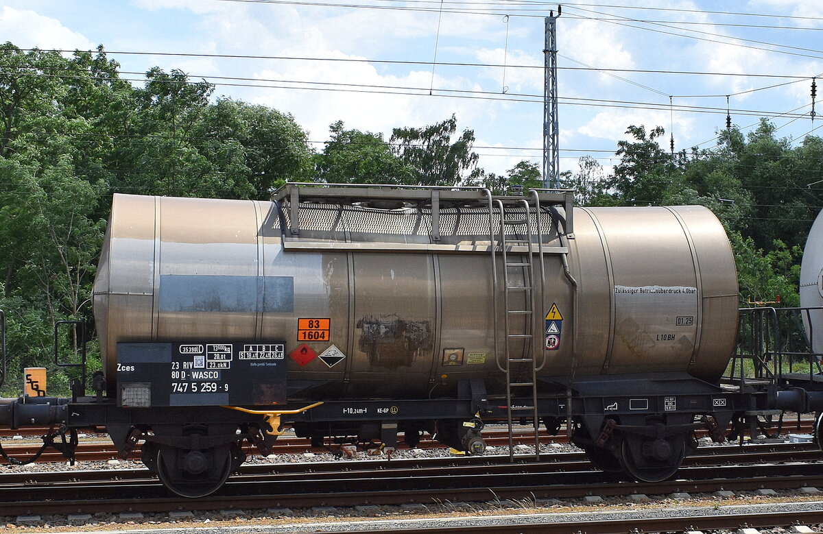 Ein zweiachsiger Kesselwagen vom Einsteller WASCOSA AG mit der Nr. 23 RIV 80 D-WASCO 747 5 259-9 Zces für lt. UN-Nr.: 83/1604 das Ladegut Ethylendiamin wurde mit einer ganzen Reihe anderer Kesselwagen vom Werksgelände BASF Schwarzheide zum Abholen zu den Abstellgleisen am Bahnhof Ruhland gebracht, 21.06.23