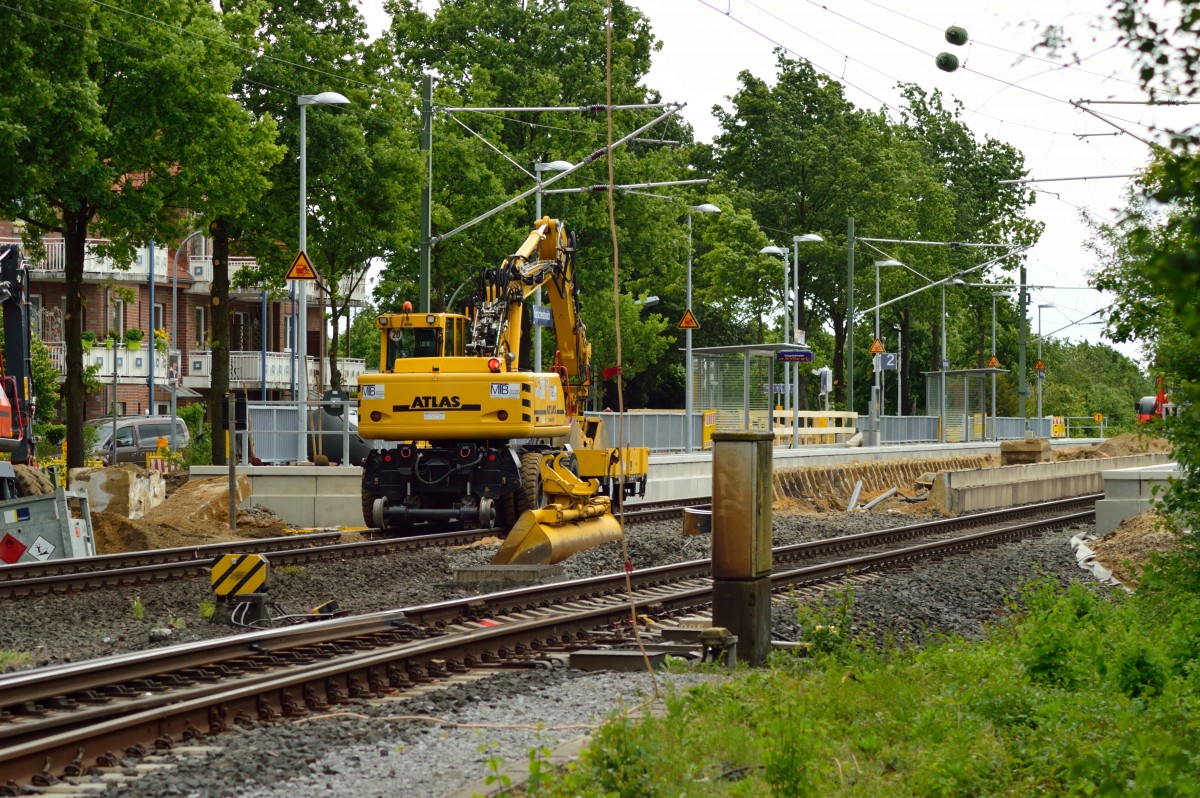 Ein Zweiwegebagger der Firma MTB steht am neu errichteten Seitenbahnsteig in Korschenbroich. Zwischen den Gleisen sieht man die Fundamente des schon teilweise abgerissenen Mittelbahnsteigs....Korschenbroich den 11.5.2014