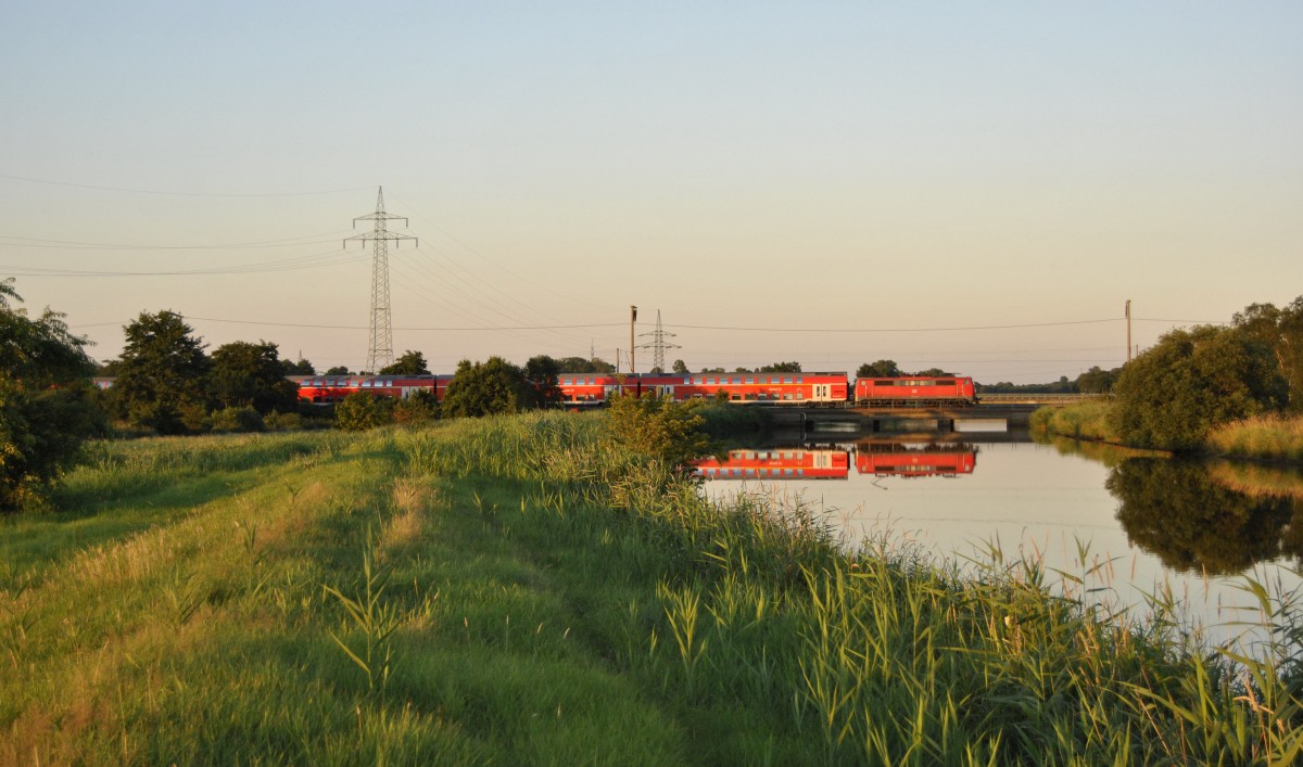 Eine 111 fuhr am 01.08.2013 mit einem RE von Emden nach Münster, hier beim Sauteler Kanal bei Neermoor.