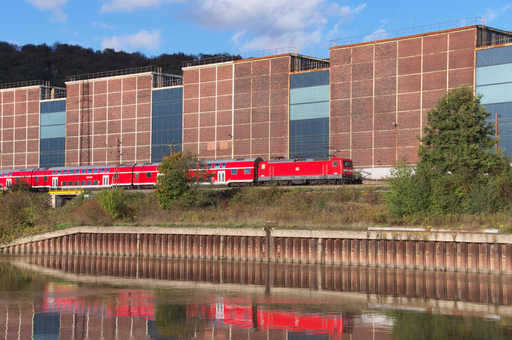 Eine 143er schiebt in der Herbstsonne des 29.10.2013 ihren Regionalexpress von Saarbrcken nach Koblenz. Hier in den Hallen der Saarstahl Vlklingen beim  Nauweiler Gewann  befand sich das Walzwerk der Rchling´schen Eisen- und Stahlwerke.