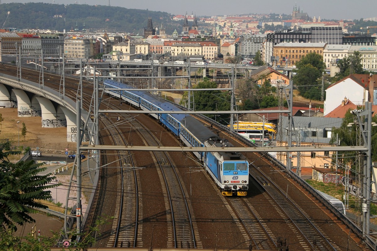 Eine 362 120-8 in blau mit farblich passenden Waggons verlässt Prag.. Bild am 12.08.2015 von einem Hügel beim Národní památník na Vítkově Park geknipst.