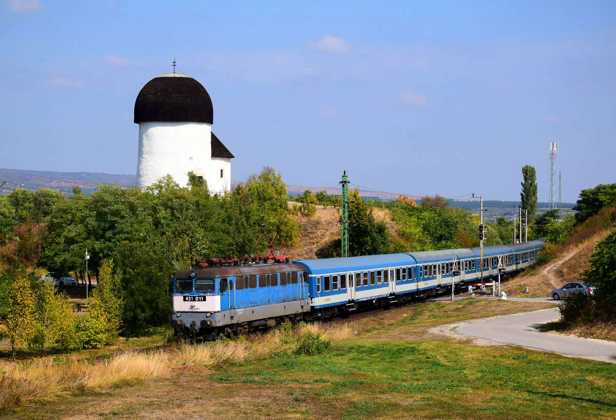 Eine der ältesten Lokomotiven von BR 431 (V43) ist die 011-er (ex. V43 1011). Die Altbau Lok ist mit dem  Göcsej Intercity  IC 954 von Budapest nach Zalaegerszeg. Das seltsame Gebäude im Hintergrund ist die  Rotunda  , die romanische Rundkirche aus dem 11. Jahrhundert.
Öskü, 26.09.2021.