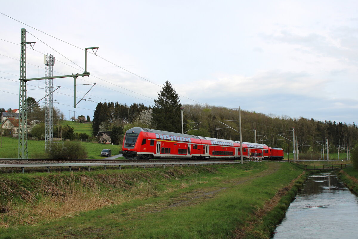 Eine Baureihe 146 schiebt ihren Dosto-Park auf dem Weg nach Stuttgart über die Südbahn zwischen Mochenwangen und Aulendorf. (30.04.2022)