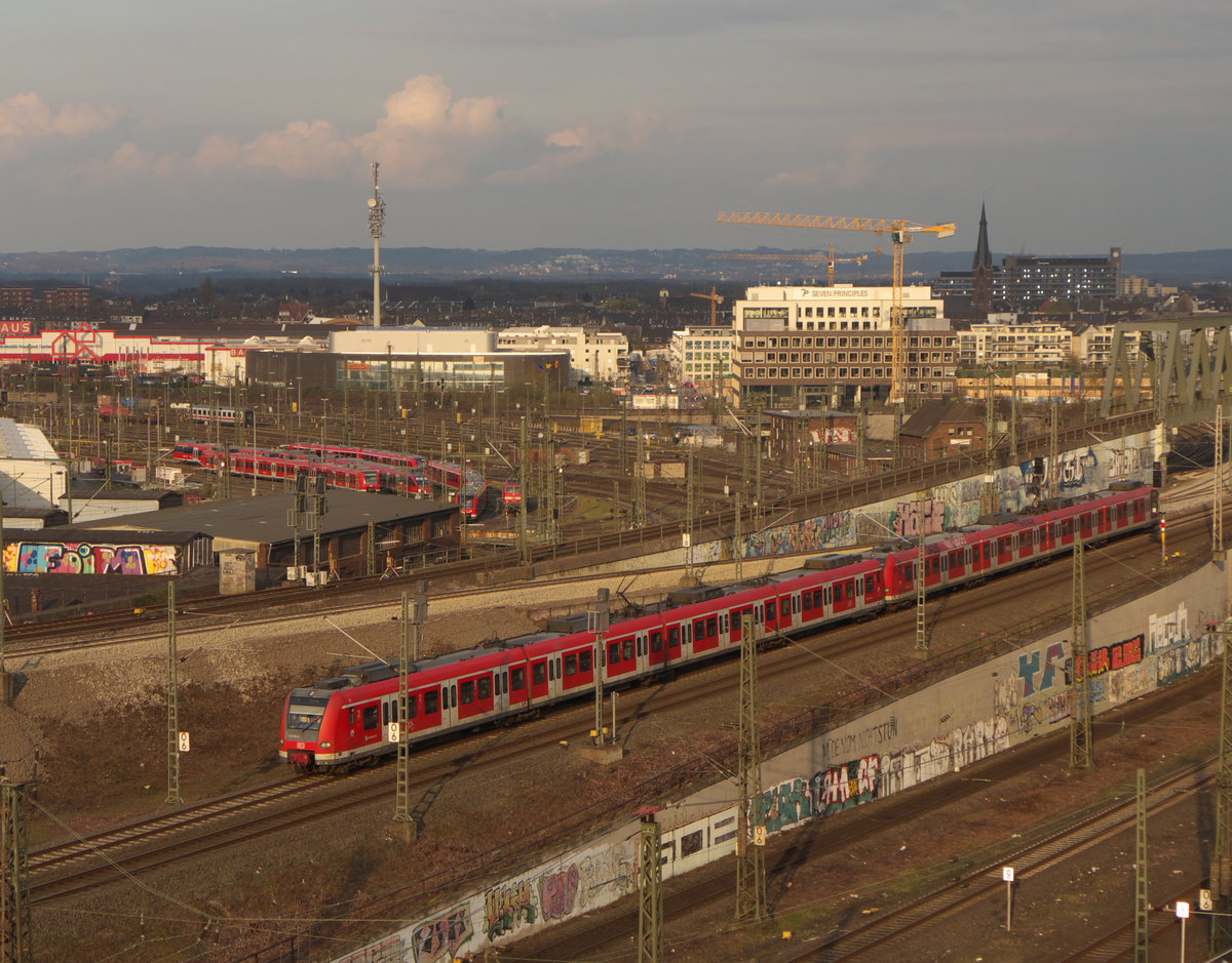 Eine Baureihe 423 der S-Bahn Köln ist unterwegs auf der Linie S13 (Troisdorf - Düren) und erreicht in kürze seinen nächsten Halt Köln Messe/Deutz. Aufgrund von Bauarbeiten fährt er auf den Gleisen des Regional- und Fernferkehrs.
Im Hintergrund ist ein Teil des Betriebsbahnhofes Köln-Deutzerfeld zu sehen.
(08.04.2016)