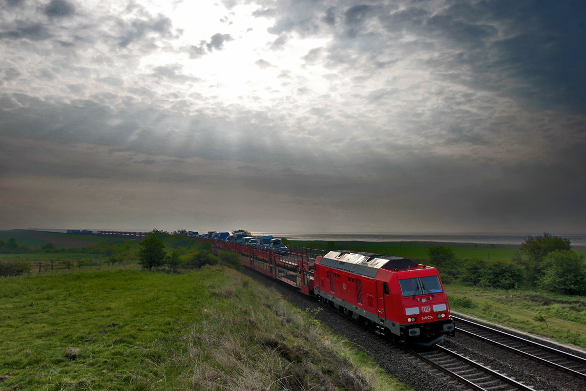 Eine beinahe unbeschreibliche Lichtstimmung liegt über der Nordsee als die Diesellokomotive 245 024 frühmorgens mit einem Sylt Shuttlezug in Morsum aufs Festland fährt.Bild Mai 2016