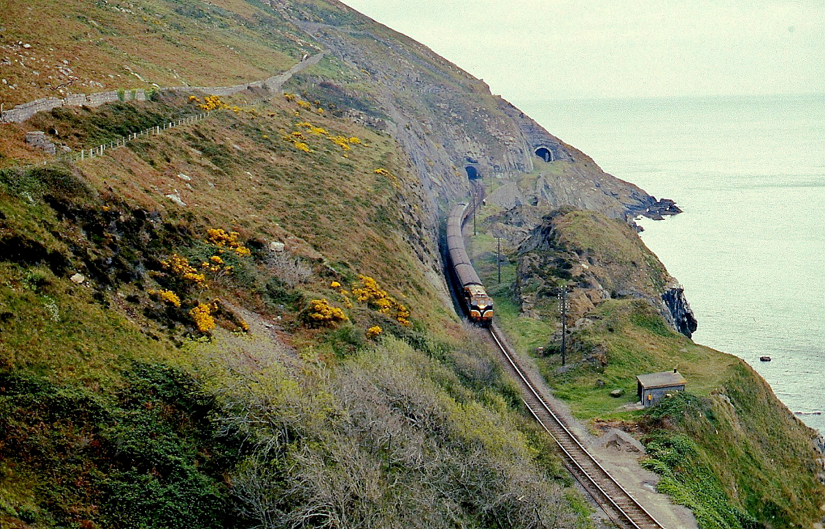 Eine Class 141 oder 181 der CIE (Coras Iompair Eireann) umfährt im April 1992 mit einem Personenzug von Dublin in Richtung Rosslaire den Bray Head