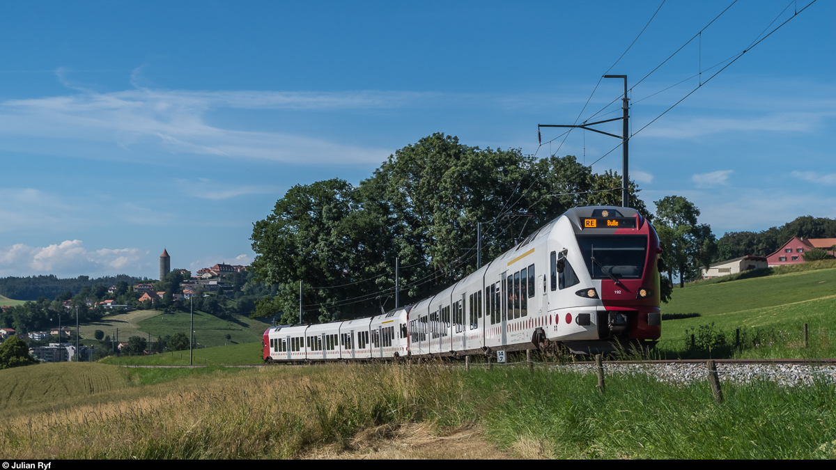 Eine Doppeltrakion FLIRT der TPF fährt am 7. Juli 2016 bei Mézières als RE in Richtung Bulle. Auf der 18 km langen Strecke Romont - Bulle werden zwar mehrere Ortschaften durchfahren, diese besitzen jedoch keinen Bahnhof mehr und werden vom Bus bedient.