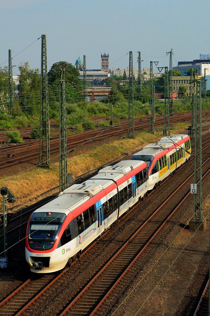 Eine Doppeltraktion der Regio-Bahn verlässt als S 28 nach Mettmann am 04.07.2015 Neuss in Richtung Düsseldorf, im Hintergrund das Quirinus-Münster