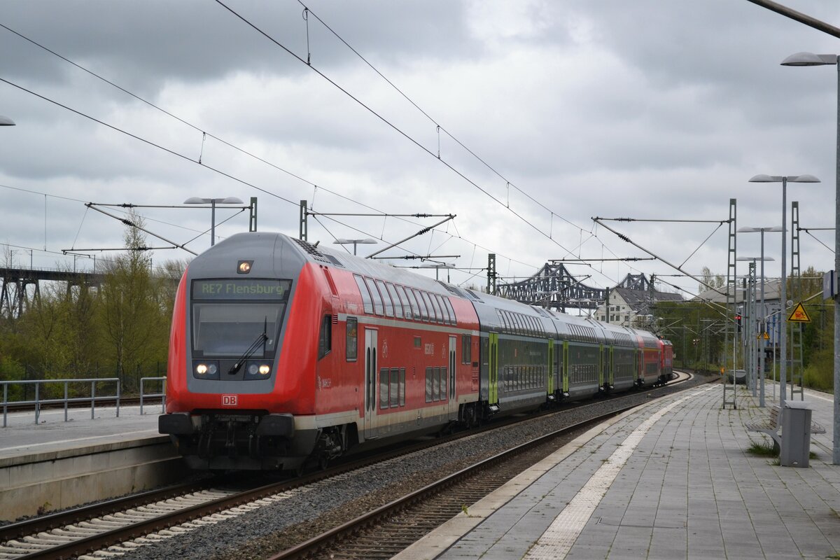 Eine Dosto-Garnitur fährt am 21.04.2017 als RE 7 nach Flensburg in den Bahnhof Rendsburg ein. Im hintergrund sieht man die Rendsburger Eisenbahnhochbrücke. 
Ort: Rendsburg, 21.04.2017