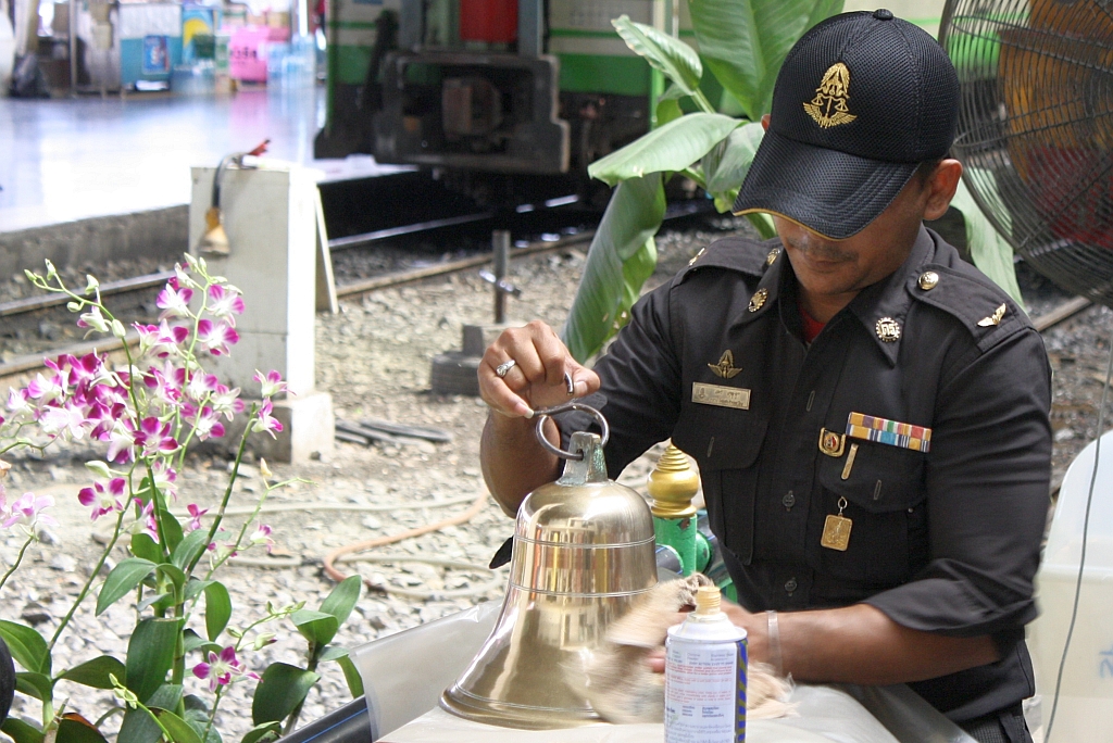 Eine für den Eisenbahnbetrieb wichtige Tätigkeit ist die Pflege der Bahnhofsglocke, wofür eigens qualifiziertes Personal herangezogen wird. Bf. Hua Lamphong am 30.Mai 2013.