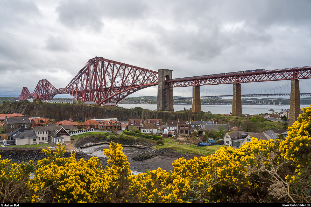 Eine für ScotRail fahrende DRS Class 68 mit einem Fife Circle Service überquert am 26. April 2019 die Forth Bridge und erreicht in Kürze den Bahnhof North Queensferry.<br>
Aufgrund von Problemen mit den neuen Hitachi-Zügen der Class 385 hat ScotRail zwei solche Komps mit Class 68 und 6 Mark-2-Wagen für HVZ-Züge auf dem Fife Circle angemietet.