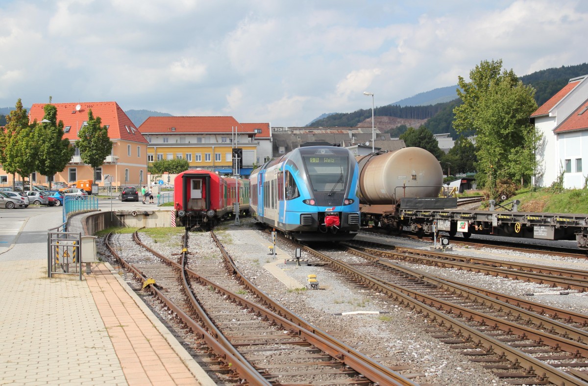 Eine Garnitur der 5062 Reihe der steirischen S Bahn, genauer gesagt der S 31, die zwischen Gleisdorf und Weiz verkehrt, fhrt vom Bahnhof Weiz (bei Km 14,8) zur Haltestelle Weiz (bei Km 15,2). Das Haltestellenhuschen bei Km 15,2 ist im rechten Bildteil zwischen dem Kesselwagen und dem Baum rechts zu sehen, Anfang September 2013