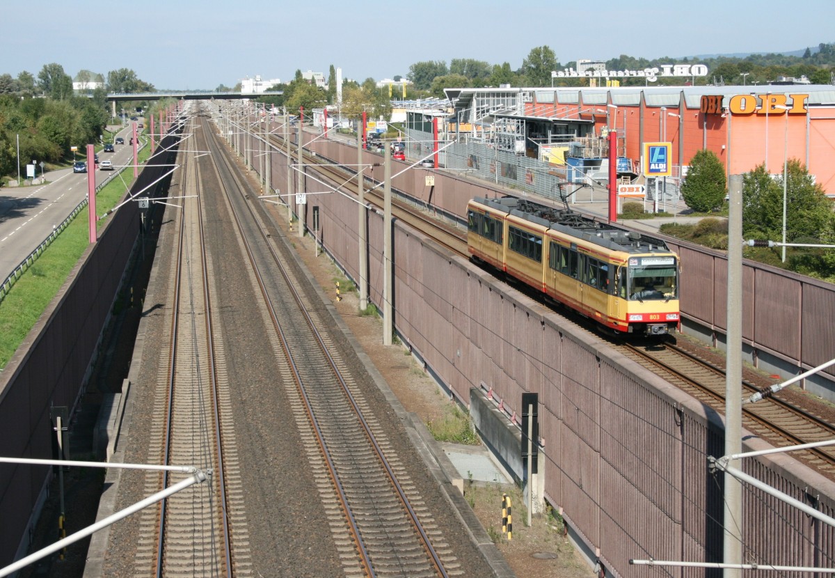 Eine der hsslichsten Bahnstrecken Deutschlands: Eingezwngt zwischen Lrmschutzwnden, Baumarkt und Strae ist AVG-ET 803 als S 85717 (Achern–Karlsruhe Marktplatz) auf der Rheintalbahn zwischen Sinzheim und Baden-Baden unterwegs.